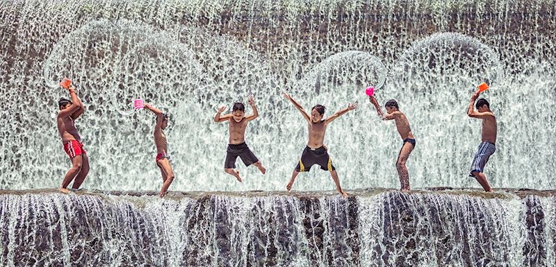 Children playing at the dam in Bali Indonesia