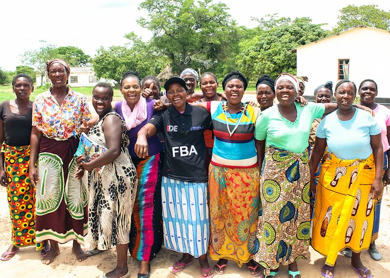 Beatrice (center) is surrounded by her farmer clients after training on her farm (© iDE/2019)