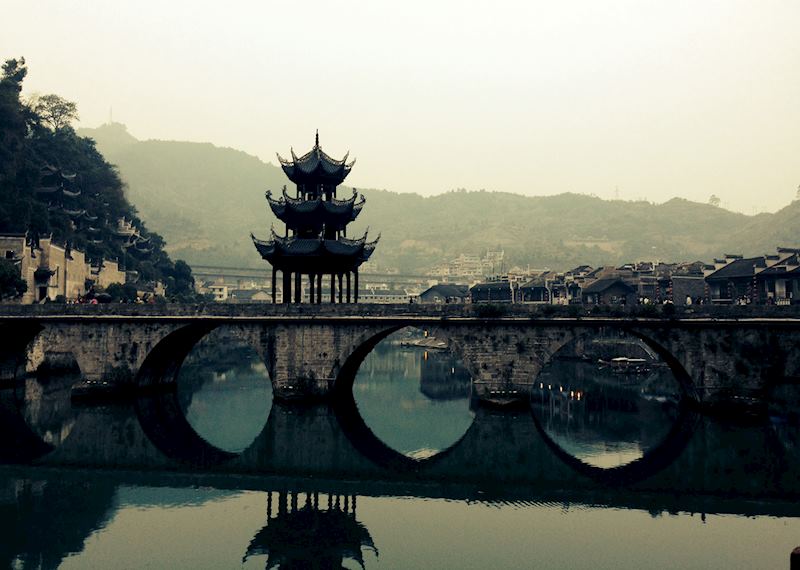 See Zhenyuan village as night falls and red lanterns light up the riverfront