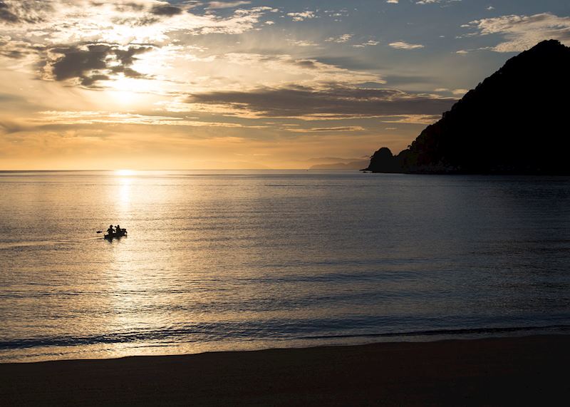 Sea kayaking at sunrise in Abel Tasman National Park, New Zealand