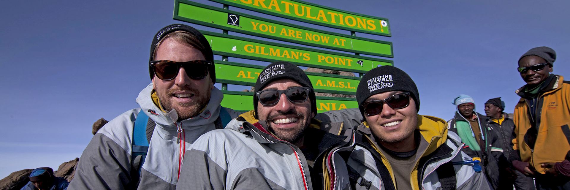 Spencer West (middle) celebrates reaching the top of Mount Kilimanjaro