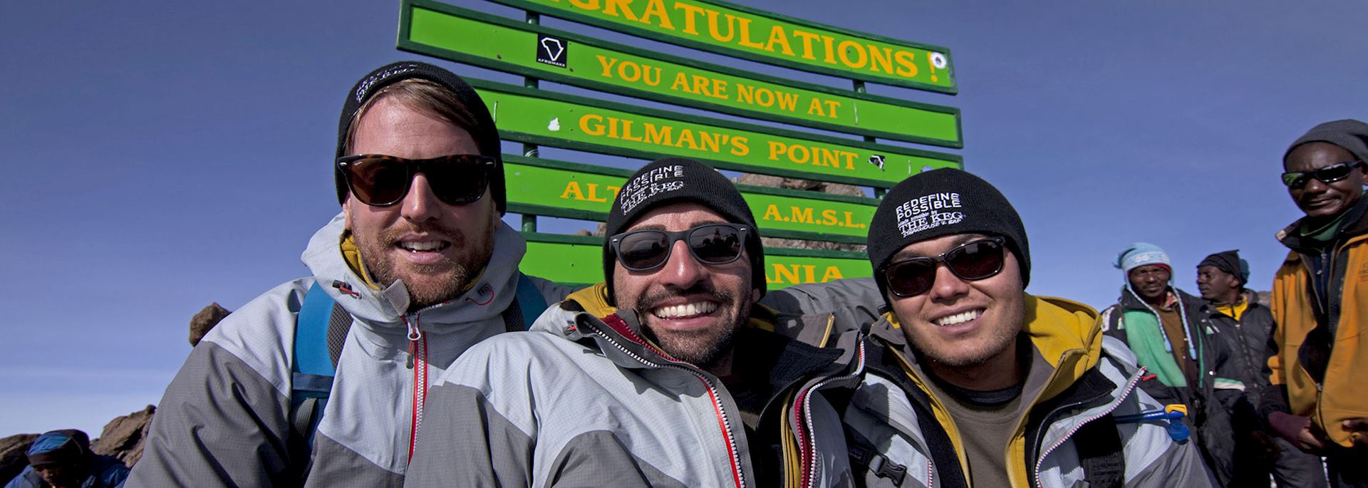 Spencer West (middle) celebrates reaching the top of Mount Kilimanjaro