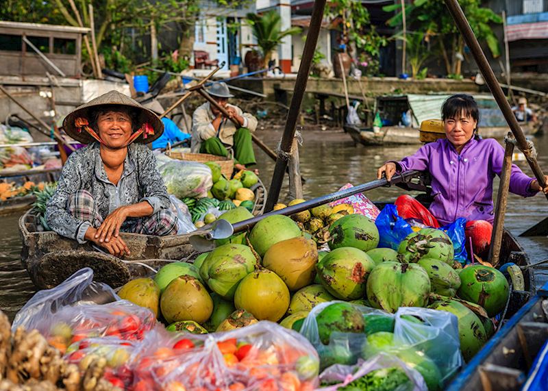 Vietnamese woman selling coconuts on floating market, Mekong River Delta.