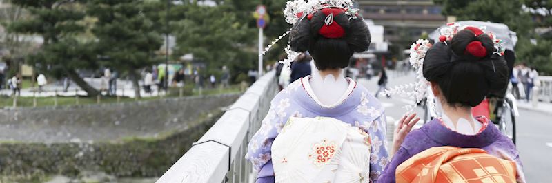 Geisha women crossing a bridge in Arashiyama