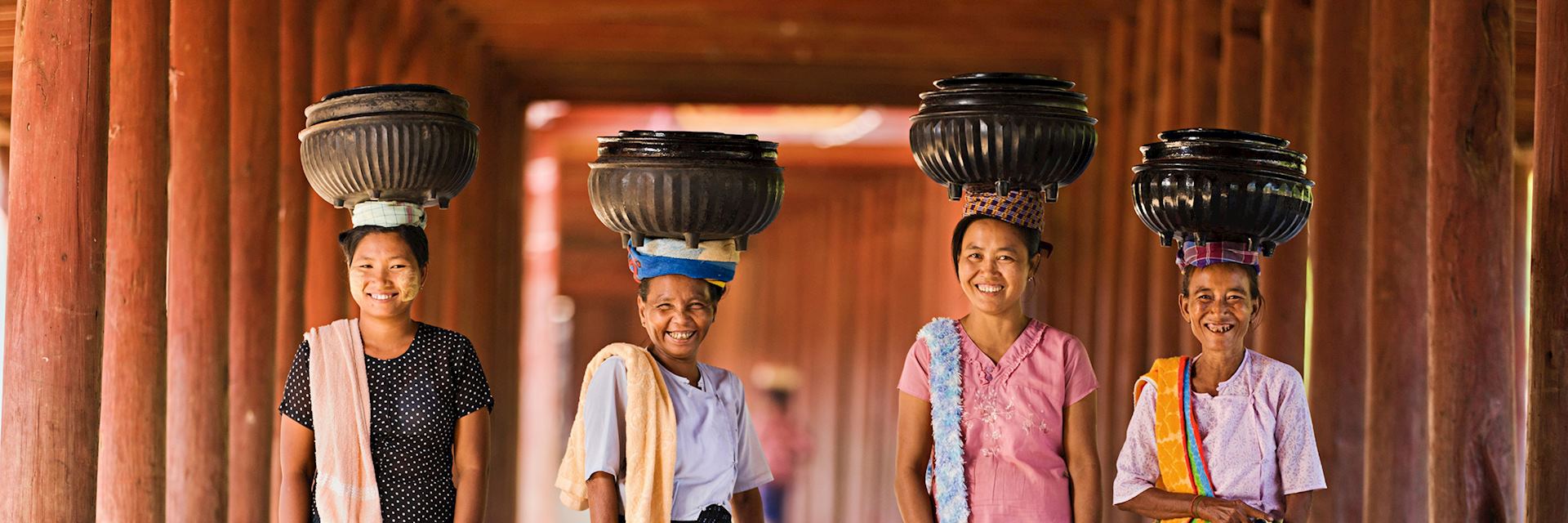 Local women carrying bowls of rice to a monastery, Myanmar
