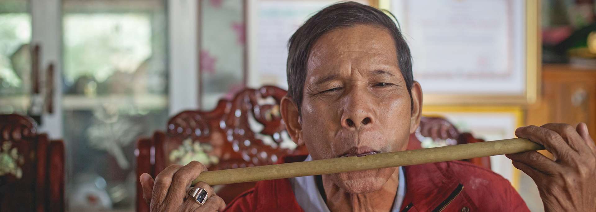 War veteran playing a bamboo instrument in Bho Hoong