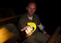 Anthony holding a chameleon during an evening game drive, South Africa