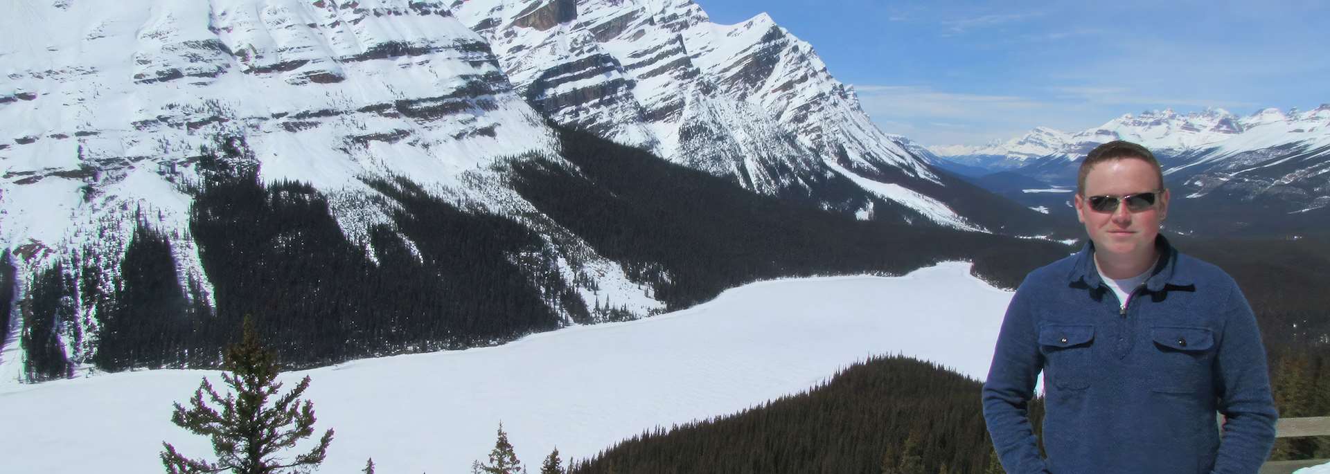 Jon looking out over a frozen Peto Lake, Canada