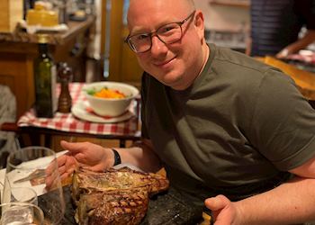 Micael trying a steak while in Bologna, Italy