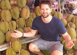 Mat among some pungent durian fruit in a market near Koh Samet, Thailand