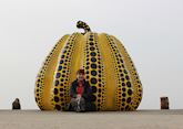 Tamatha relaxing next to the 'Yellow Pumpkin' artwork in Naoshima