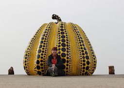 Tamatha relaxing next to the 'Yellow Pumpkin' artwork in Naoshima