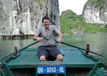 William rowing a traditional boat on Halong Bay, Vietnam
