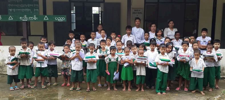 The children of Paya Ngoto School holding their new uniforms