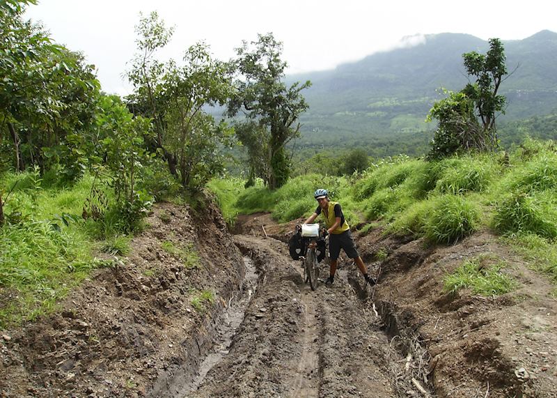 Alan struggling through the mud on a mountain road in the Guinea rainforest