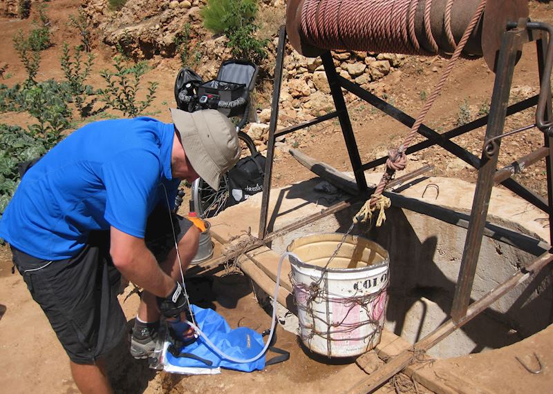 Ian purifying water from an open well in the Sahara Desert